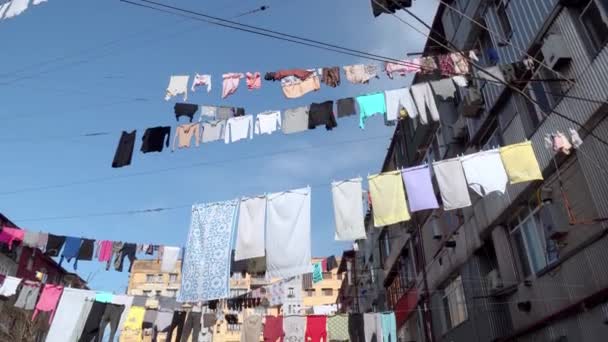 Πλυντήριο ρούχων κρέμεται σε ένα σχοινί στην αυλή ενός παλιού πολυώροφου κτιρίου. — Αρχείο Βίντεο