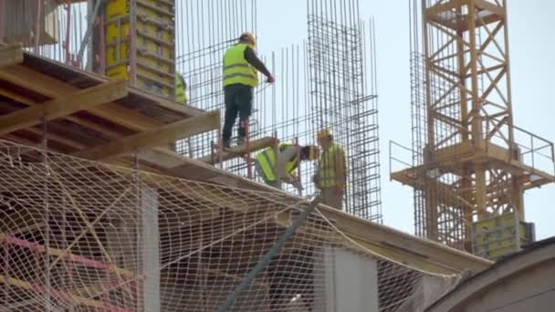 Trabajadores de la construcción a la altura del edificio. sitio de construcción. — Vídeo de stock