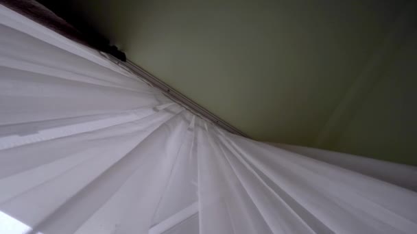 Una cortina transparente en la ventana, ligeramente balanceándose en el viento en la habitación. — Vídeo de stock