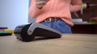 Bir kadının elinde plastik bir kredi kartı var. Kredi kartıyla ödeme.