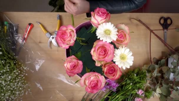 Pohled shora na ruce mladé květinářky vytvářející kompozici — Stock video
