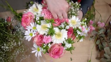 Güzel bir kompozisyon hazırlayan kadın bir çiçekçinin elleri.