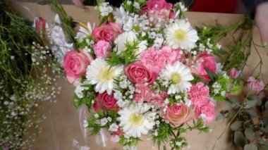 Bir kompozisyon oluşturan genç bir kadın çiçekçinin ellerinin üst görüntüsü