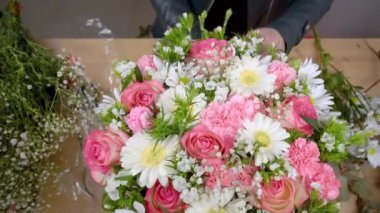 Güzel bir kompozisyon hazırlayan kadın bir çiçekçinin elleri.