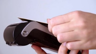 Bir kadının eli terminale plastik bir kart getirir ve bağlantısız ödeme yapar.