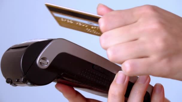 Die Hand einer Frau bringt eine Plastikkarte zum Terminal und bezahlt kontaktlos — Stockvideo