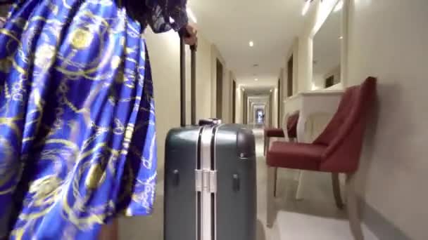 带着旅行箱的女商人正走在酒店的走廊上 在商务酒店带行李的旅行妇女 他出差到达旅馆 从后面看脚跟 — 图库视频影像