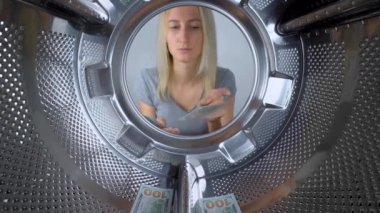 Kadın çamaşır makinesinin yanında para sayıyor, her banknotu davula atıyor ve yıkanması için bırakıyor. Çamaşır ya da aile bütçesi. Garanti altında çamaşır makinesini tamir etmek pahalıdır. Servis.