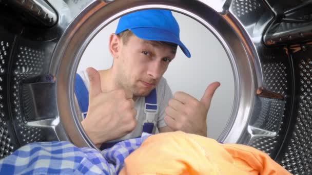 기사보기 미국의 가정용 세탁기 수리공 세탁기 내부를 들여다보고 손가락으로 몸짓이나 — 비디오