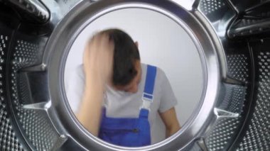 Mavi üniformalı bir ev aletleri tamircisi kafasını çamaşır makinesine soktu ve ağzından Styroco diye bağırdı. Tatminsiz ve tehlike konusunda uyarıyor. Çamaşır makinelerinin tamiri.