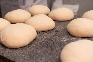 Mutfak masasındaki çörek ya da diğer buğday unları için taze hamur toplarının yakın plan çekimi. Pişirmek için boş