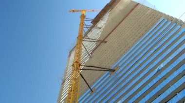 crane tower is attached to frame of building. Construction of skyscraper.