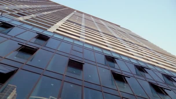 Vista inferior de rascacielos modernos en el distrito de negocios contra el cielo azul — Vídeo de stock