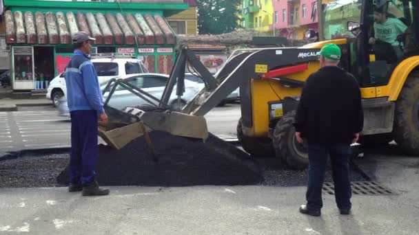 Mini bulldozer picks up asphalt with bucket of scissors. Highway engineering — Stok video