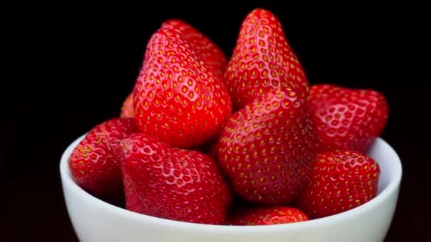 Strawberries without tails lie in white bowl or plate. It rotates — Stock videók
