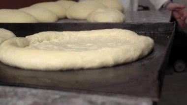 Erkek eli hamuru tutar. Pizza, ekmek ya da ekmek için çiğ hamur yapmak..