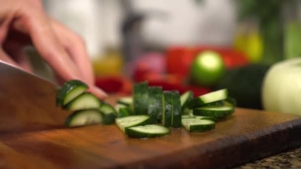 Female housewife prepares healthy food in kitchen. She cuts vegetables, — Stockvideo