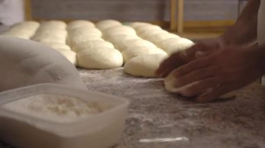 Men's hands hold dough. making raw dough for pizza, rolls or bread.