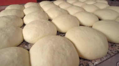 Close-up of finished pink dough in bakery on wooden table.