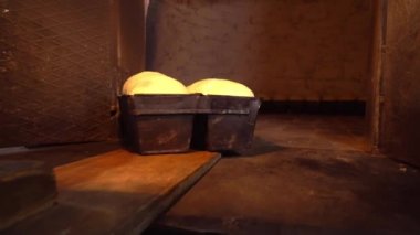 Fırıncı ekmek hamurunu kürekle fırına koyar.