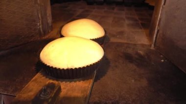 Fırıncı ekmek hamurunu kürekle fırına koyar.