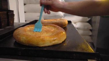 Eriyen tereyağını fırçayla tarayan bir aşçı.