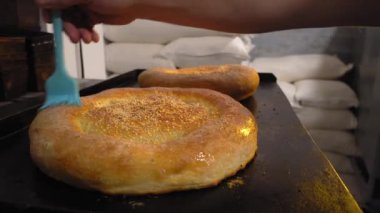 Eriyen tereyağını fırçayla tarayan bir aşçı.