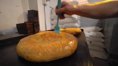 Eriyen tereyağını fırçayla tarayan bir aşçı.