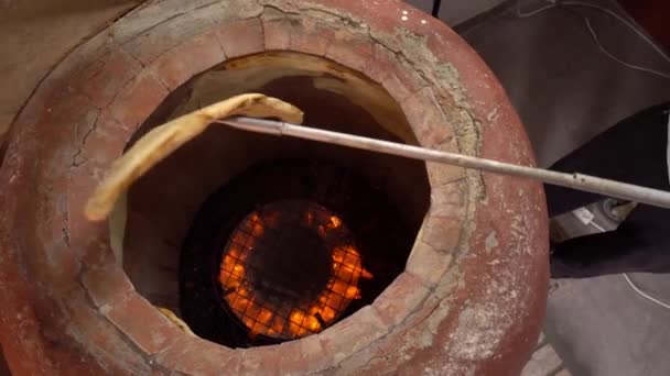 Baker maakt Turkse lavash in tandoor, klei oven. Bakproces. — Stockvideo