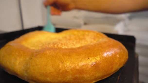 Ένα μάγειρα χτένισμα βούτυρο τήξης με πινέλο στο ψημένο ψωμί — Αρχείο Βίντεο