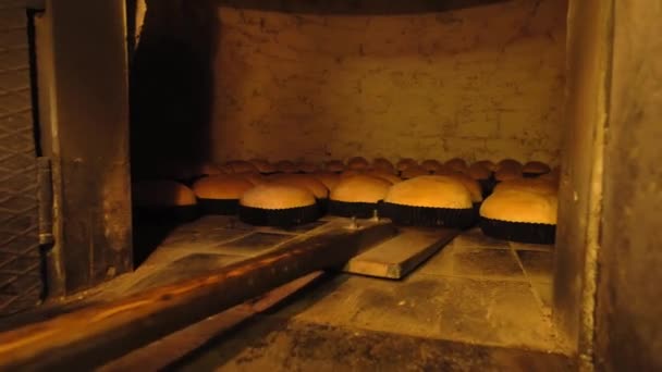 Пекарь выносит хлеб в духовку с лопатой. — стоковое видео
