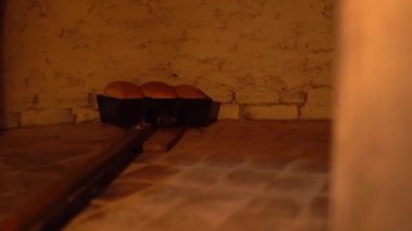 Baker ekmeği kürekle fırına atar..