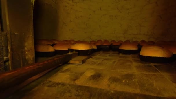 Baker takes bread out into oven with shovel. — Vídeos de Stock