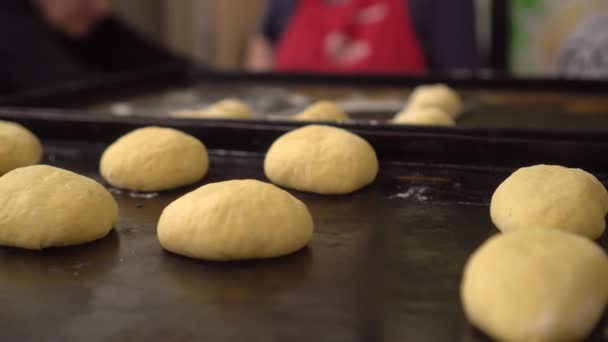 Close-up van afgewerkt roze deeg in bakkerij op houten tafel. — Stockvideo