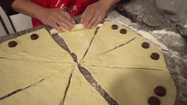 Женщина крутит куски и готовит круассан — стоковое видео