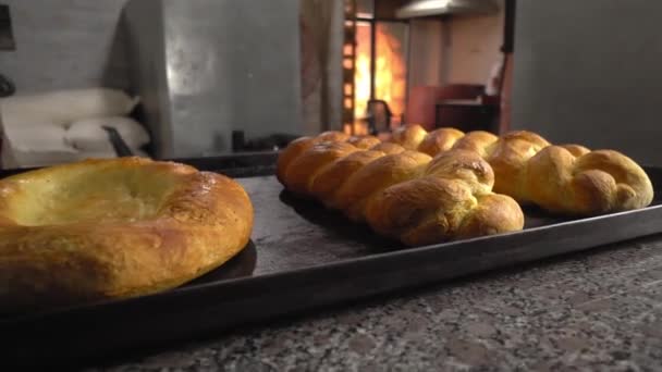 Gebäck in Form von Brötchen und Brot liegen auf dem Tisch vor Backstube — Stockvideo