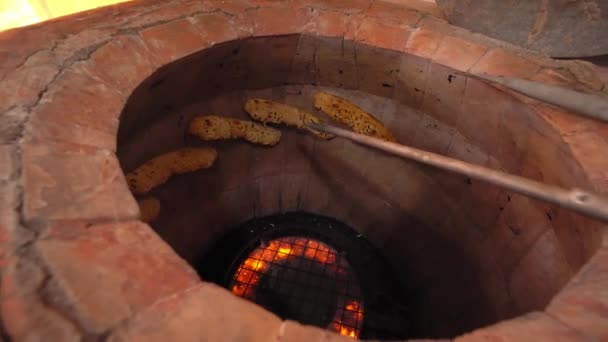 Piekarz robi turecką toaletę w garbarni, gliniany piekarnik. Proces pieczenia. — Wideo stockowe