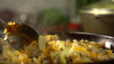 Et ve sebzeli kızartma tavası. Dişi rka içeriği karıştırır.