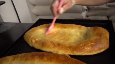 Eriyen tereyağını fırçayla tarayan bir aşçı.
