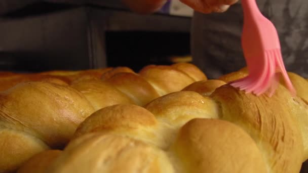 Ein Koch kämmt schmelzende Butter mit Pinsel auf gebackenem Brot — Stockvideo
