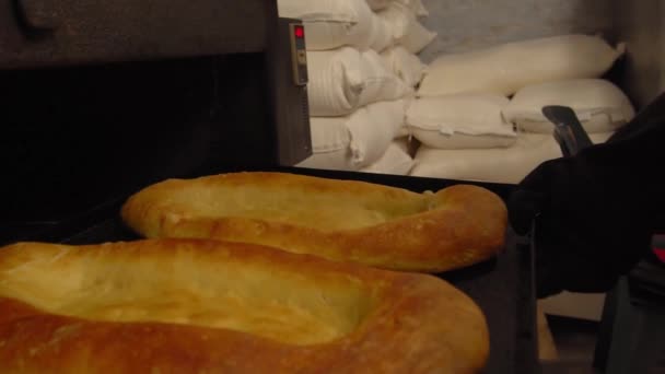Baker takes bread out into oven with shovel. — Vídeos de Stock