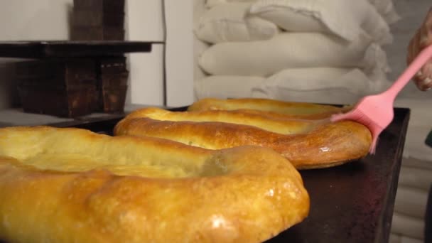 Ein Koch kämmt schmelzende Butter mit Pinsel auf gebackenem Brot — Stockvideo