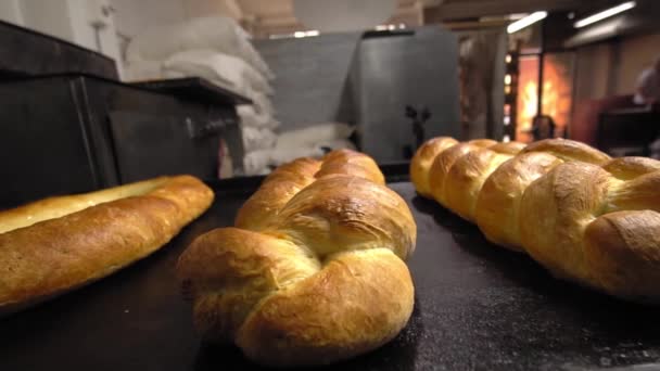 Gebäck in Form von Brötchen und Brot liegen auf dem Tisch vor Backstube — Stockvideo