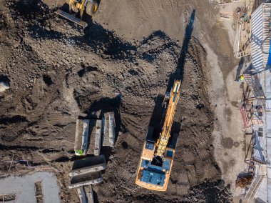 İnşaat alanı, kazıcı ve traktörün drone görüntüsü. Hava fotoğrafçılığı.