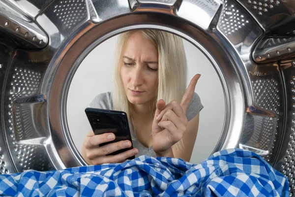 Young Woman Looks Thoughtfully Her Mobile Phone Searches Something Holding — Foto Stock