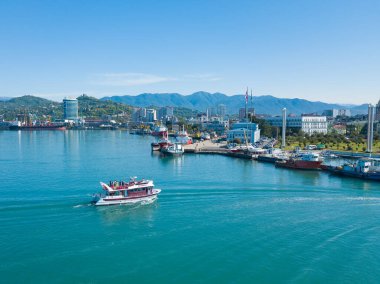 Batum, Gürcistan - 22 Mayıs 2022: Güneşli bir günde şehrin limanına giren bir zevk gemisinin insansız hava aracı görüntüsü