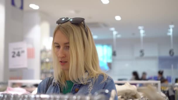 Beautiful Young Caucasian Woman White Hair Chooses Clothes Store Shopping — Stockvideo