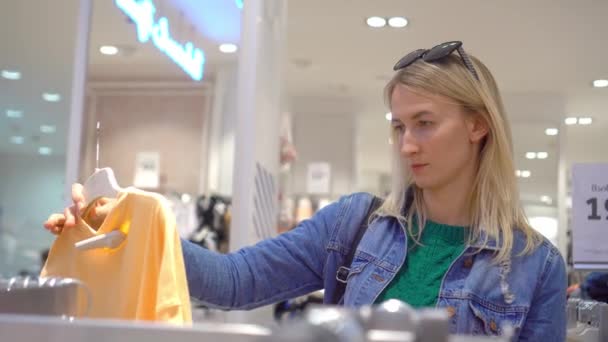 Krásná Mladá Běloška Bílými Vlasy Vybírá Oblečení Obchodě Nebo Nákupním — Stock video