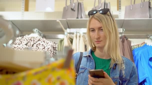 Mladá Krásná Bulrndinka Žena Používá Smartphone Obchodě Oblečením Nebo Nákupního — Stock video