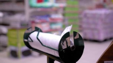 Kadın eli, süpermarketin sebze reyonunda ya da markette paketleme poşetlerinden bir paket polietilen alır. Bedava paketlerle ayakta durun - selofan paketleme. Çevre kirliliği